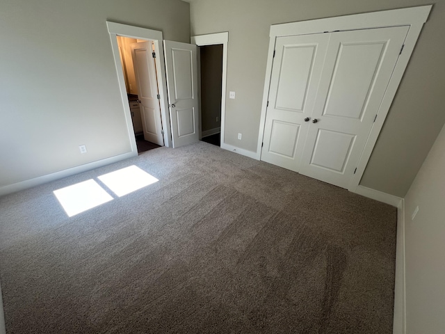 unfurnished bedroom featuring baseboards, carpet, and a closet