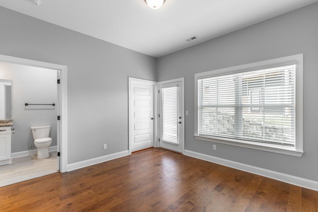 3495 Travertine Ln, Chattanooga, TN 37405 - unfurnished bedroom featuring baseboards, visible vents, wood finished floors, and connected bathroom