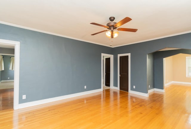 empty room featuring baseboards, light wood-style floors, ceiling fan, and crown molding