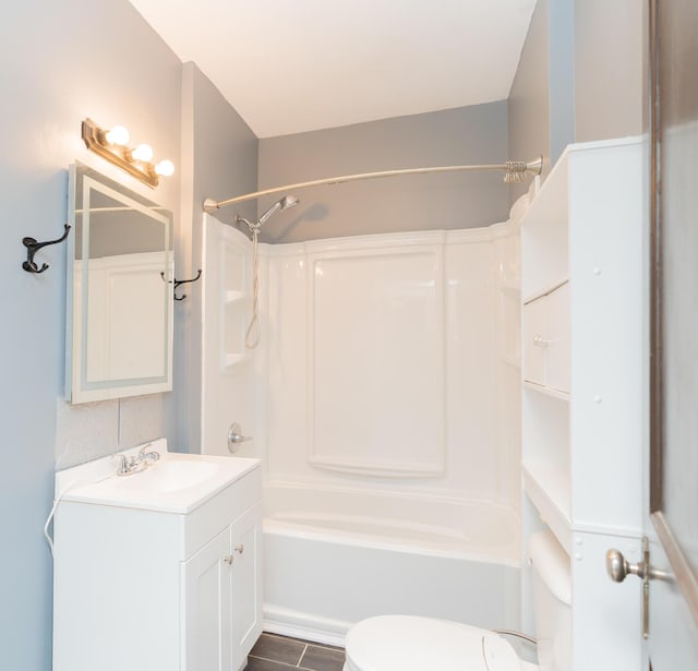 bathroom featuring toilet, vanity, and  shower combination