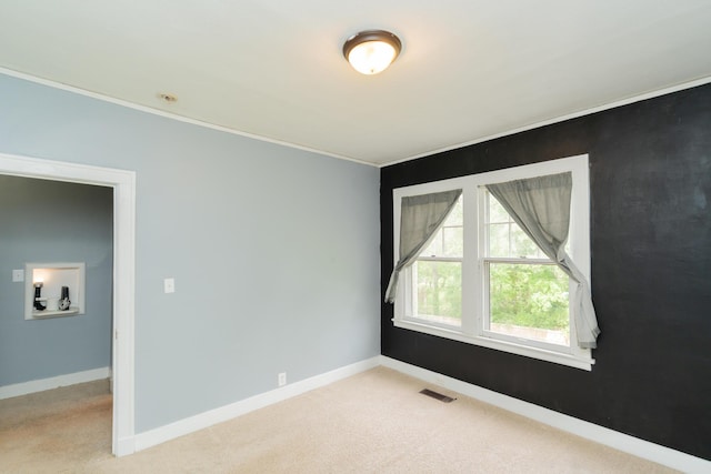 unfurnished room with baseboards, visible vents, carpet, and crown molding