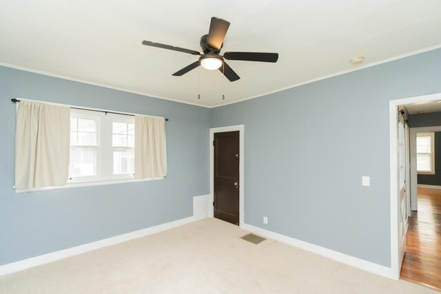 unfurnished bedroom with baseboards, visible vents, ornamental molding, and ceiling fan