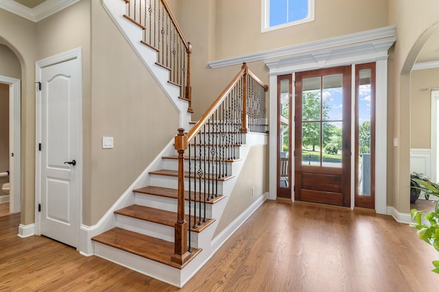 8209 Robertsview Dr, Ooltewah, TN 37363 - entrance foyer featuring arched walkways, ornamental molding, healthy amount of natural light, wood finished floors, and stairway