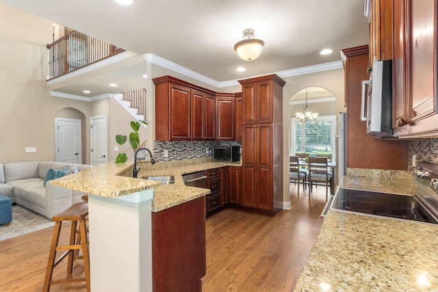 8209 Robertsview Dr, Ooltewah, TN 37363 - kitchen featuring a sink, appliances with stainless steel finishes, arched walkways, a peninsula, and crown molding