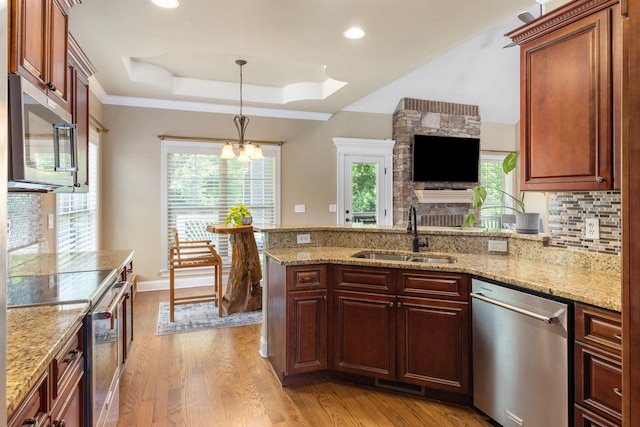 8209 Robertsview Dr, Ooltewah, TN 37363 - kitchen with appliances with stainless steel finishes, a sink, a peninsula, a chandelier, and a raised ceiling