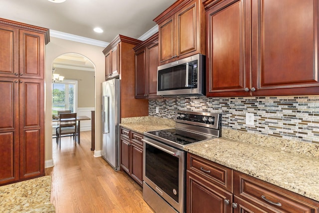 8209 Robertsview Dr, Ooltewah, TN 37363 - kitchen with appliances with stainless steel finishes, crown molding, light wood finished floors, arched walkways, and backsplash