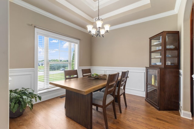 8209 Robertsview Dr, Ooltewah, TN 37363 - dining space with a chandelier, ornamental molding, dark wood-style flooring, a tray ceiling, and a wainscoted wall