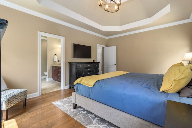 8209 Robertsview Dr, Ooltewah, TN 37363 - bedroom featuring a tray ceiling, a chandelier, wood finished floors, crown molding, and connected bathroom