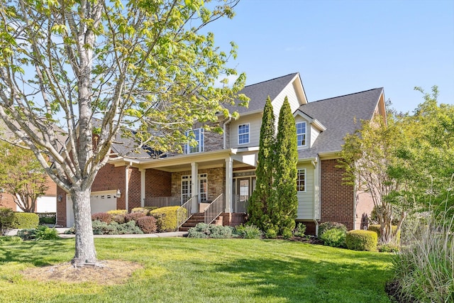 view of front facade featuring covered porch, brick siding, and a front lawn