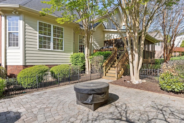 view of patio featuring fence and stairway