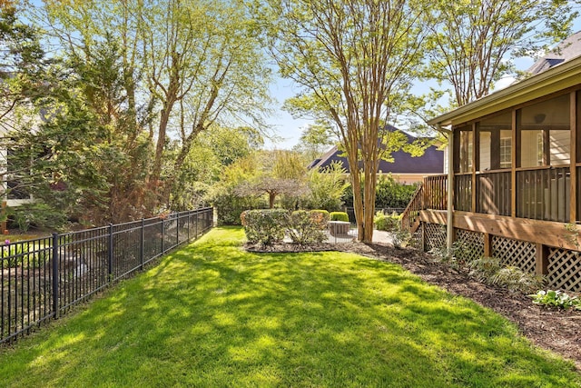 view of yard with a sunroom, a fenced backyard, and a wooden deck