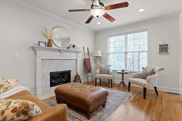 living area with light wood-style floors, a fireplace, a ceiling fan, baseboards, and recessed lighting