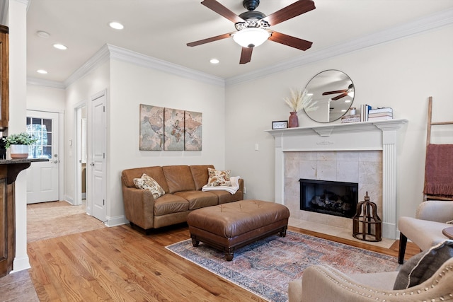 living area with recessed lighting, light wood-style floors, ceiling fan, and a tiled fireplace