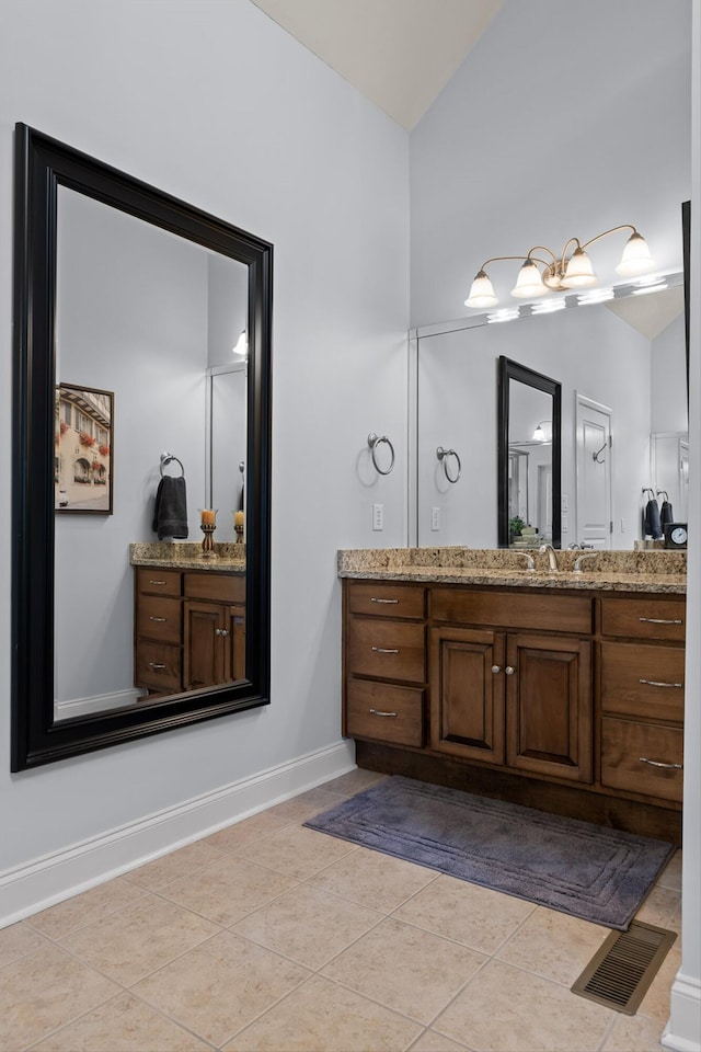 bathroom with visible vents, tile patterned flooring, vaulted ceiling, vanity, and baseboards