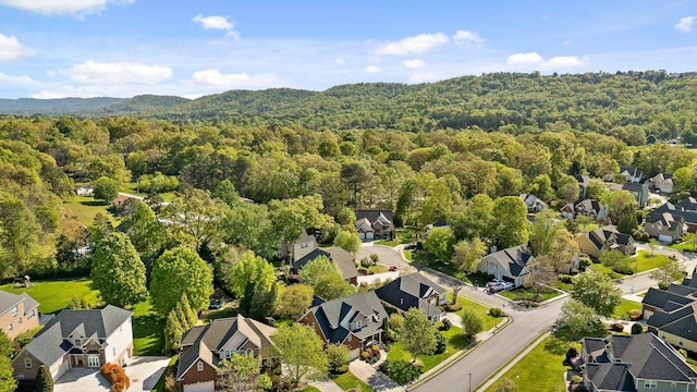 drone / aerial view with a wooded view and a residential view