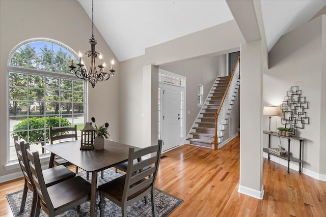 3874 Sweet Bay Ln, Apison, TN 37302 - dining space with stairs, light wood-style floors, baseboards, high vaulted ceiling, and a notable chandelier
