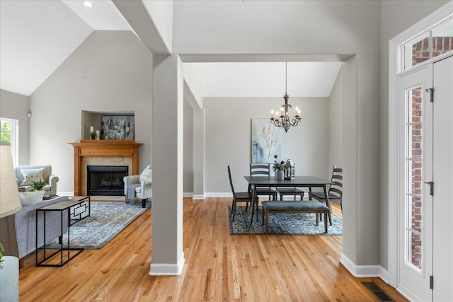 3874 Sweet Bay Ln, Apison, TN 37302 - dining area featuring a chandelier, a tiled fireplace, visible vents, and light wood-style floors