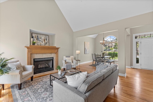 3874 Sweet Bay Ln, Apison, TN 37302 - living area with a fireplace with flush hearth, light wood finished floors, an inviting chandelier, baseboards, and high vaulted ceiling