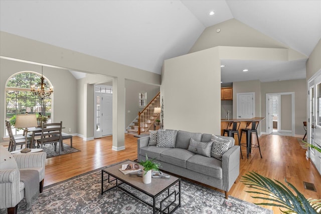 3874 Sweet Bay Ln, Apison, TN 37302 - living area featuring stairway, high vaulted ceiling, a chandelier, light wood-style floors, and visible vents