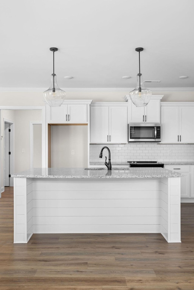 370 Winchester Dr Unit 70, Rossville, GA 30741 - kitchen with stainless steel microwave, backsplash, white cabinets, a kitchen island with sink, and crown molding