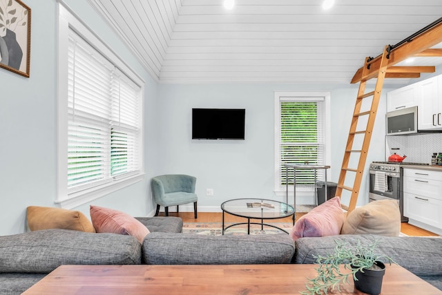 5107 Beulah Ave, Chattanooga, TN 37409 - living area featuring light wood finished floors, lofted ceiling, baseboards, and a bar