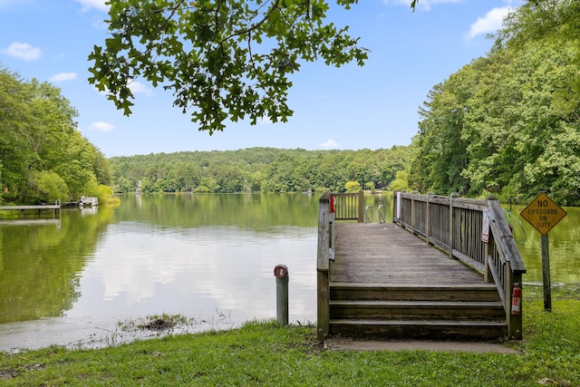 view of dock featuring a water view and a wooded view