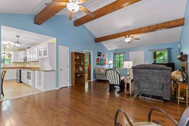 living room with ceiling fan, lofted ceiling with beams, and light wood-style flooring