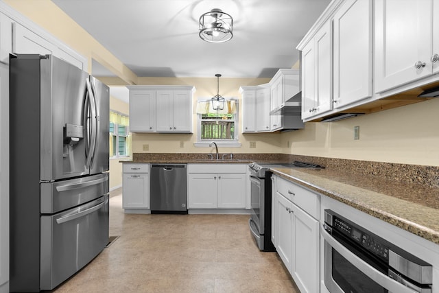 kitchen with a sink, white cabinetry, appliances with stainless steel finishes, and wall chimney range hood