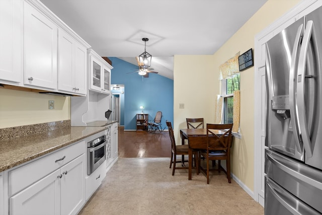kitchen with light stone countertops, white cabinetry, a ceiling fan, decorative light fixtures, and stainless steel appliances
