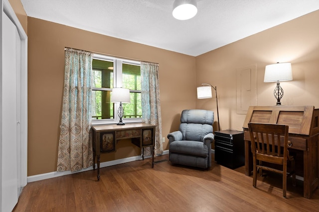 living area featuring baseboards and wood finished floors