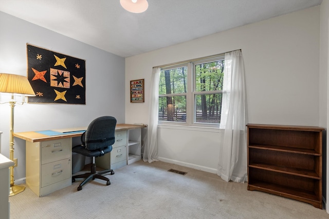 home office featuring visible vents, baseboards, and light colored carpet