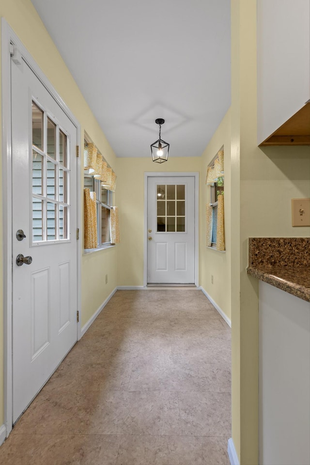 doorway featuring baseboards