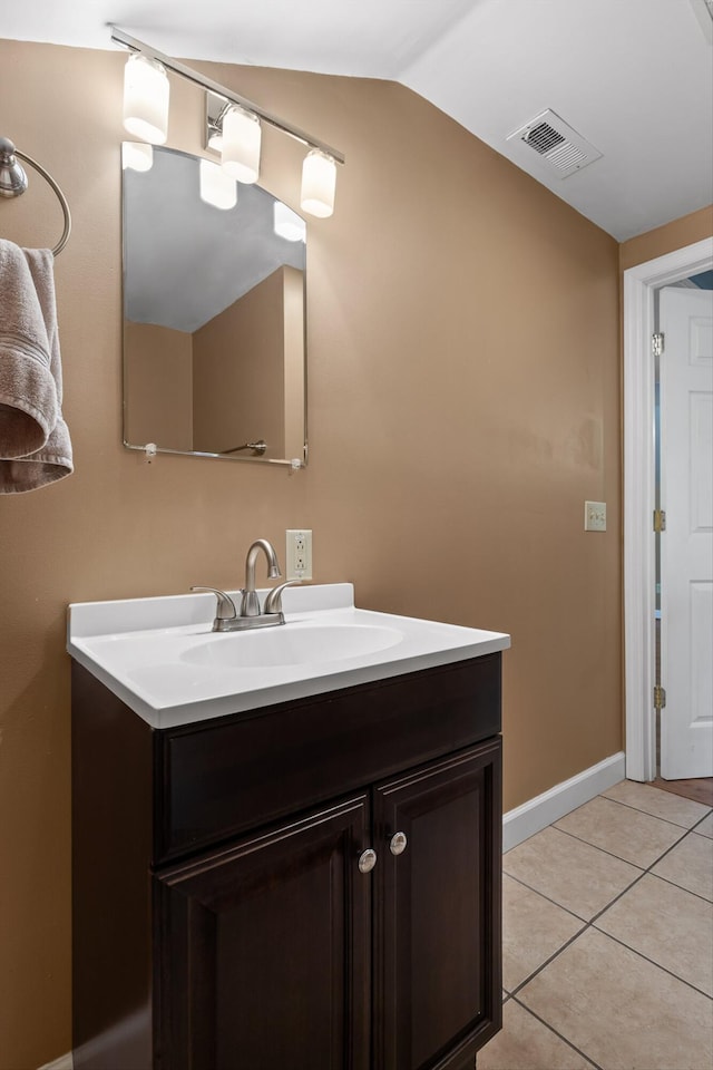 bathroom with visible vents, tile patterned flooring, vanity, baseboards, and vaulted ceiling