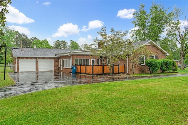 exterior space with a garage, a front yard, driveway, and brick siding