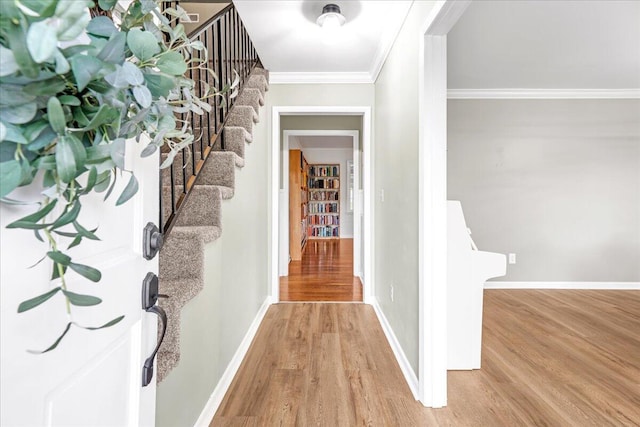 interior space featuring crown molding, baseboards, stairway, and light wood-type flooring
