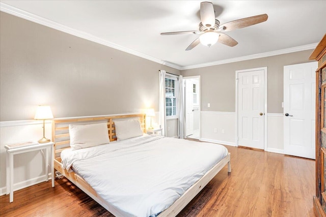 bedroom featuring ornamental molding, light wood finished floors, and ceiling fan