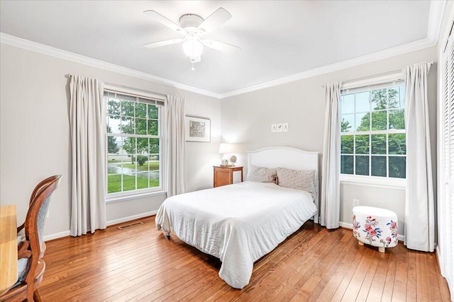 bedroom featuring multiple windows, ornamental molding, and hardwood / wood-style floors
