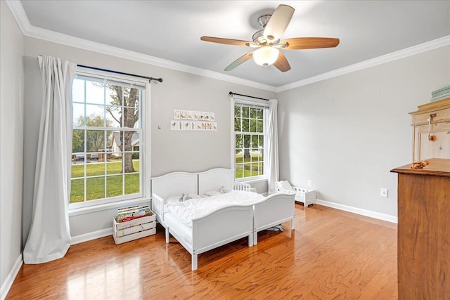 bedroom with wood finished floors and multiple windows