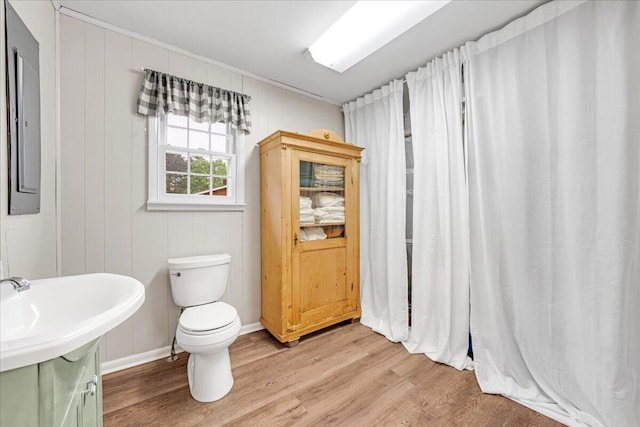 bathroom featuring a sink, baseboards, toilet, and wood finished floors