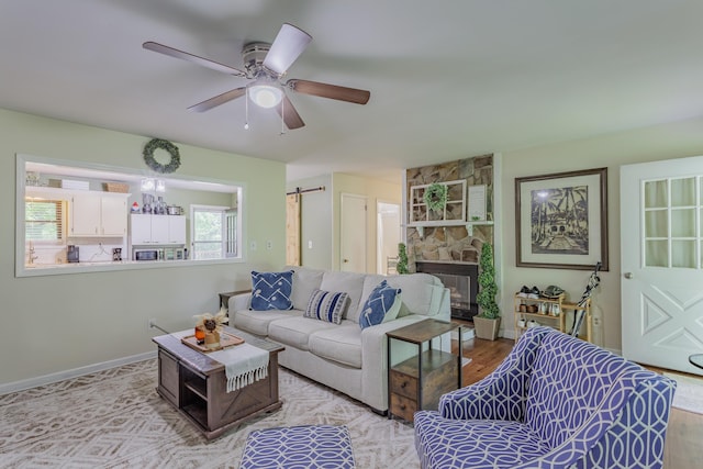 2031 Millard Rd, Soddy Daisy, TN 37379 - living room with a fireplace, a ceiling fan, light wood-style floors, and baseboards