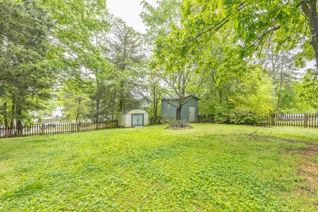2031 Millard Rd, Soddy Daisy, TN 37379 - view of yard featuring a storage unit, a fenced backyard, and an outdoor structure