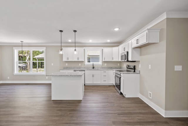 kitchen with a center island, baseboards, stainless steel appliances, and a sink