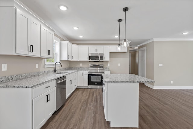 kitchen with a center island, crown molding, stainless steel appliances, white cabinets, and dark wood-style floors