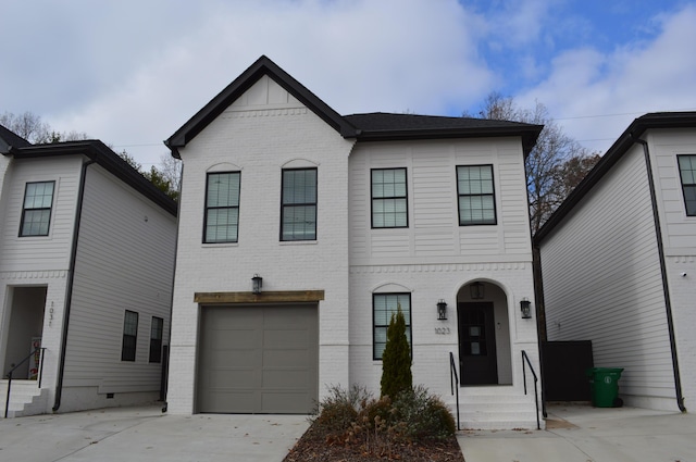 view of front of home with concrete driveway, brick siding, and a garage