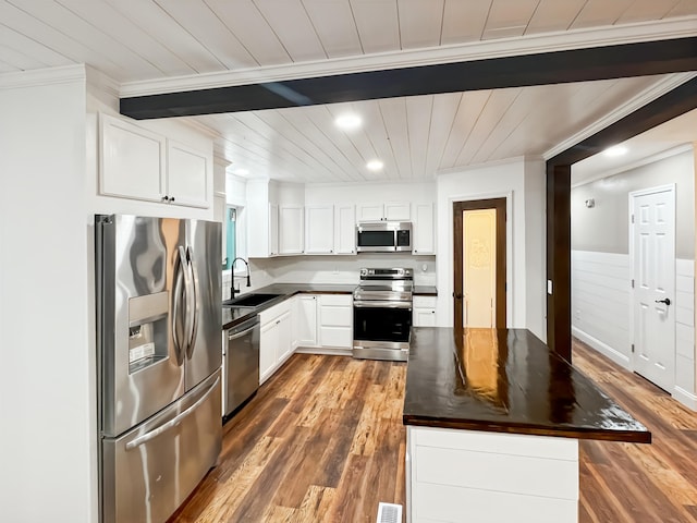 1157 Boy Scout Rd, Hixson, TN 37343 - kitchen with appliances with stainless steel finishes, crown molding, wood finished floors, a center island, and white cabinetry