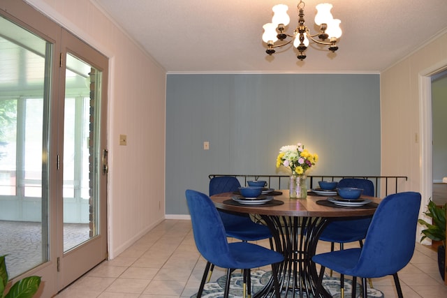 dining area with light tile patterned floors, ornamental molding, and a notable chandelier