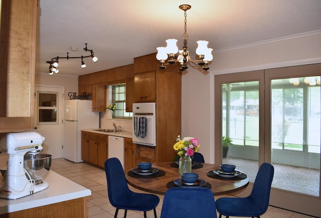 dining space with ornamental molding, light tile patterned flooring, a notable chandelier, and a textured ceiling