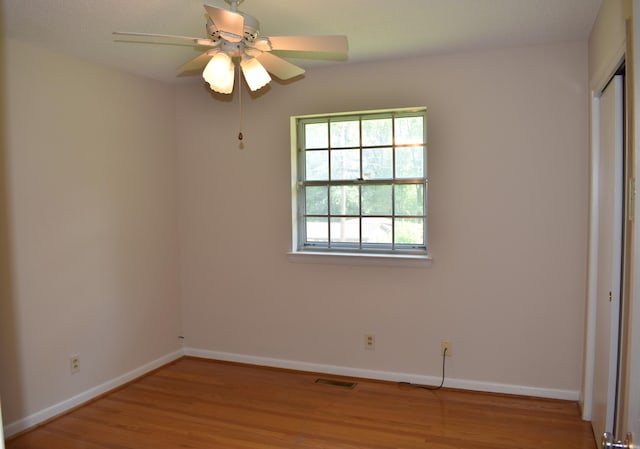 unfurnished bedroom featuring wood finished floors, a closet, visible vents, and baseboards