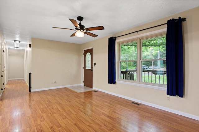 unfurnished living room with visible vents, light wood-type flooring, and baseboards