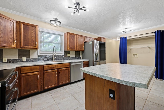 kitchen with light tile patterned floors, a sink, stainless steel appliances, light countertops, and a center island